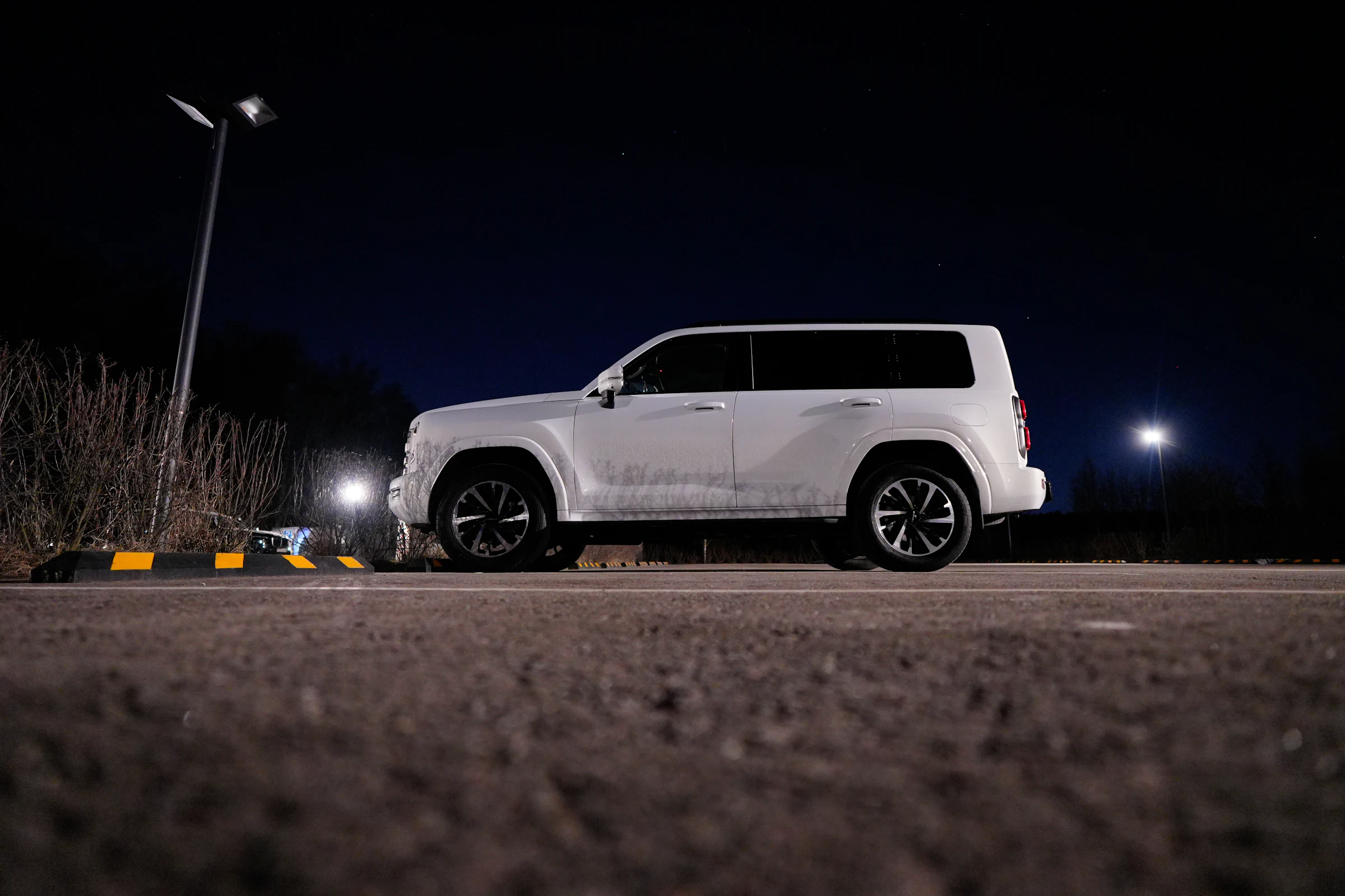 White SUV parked under a streetlight at night